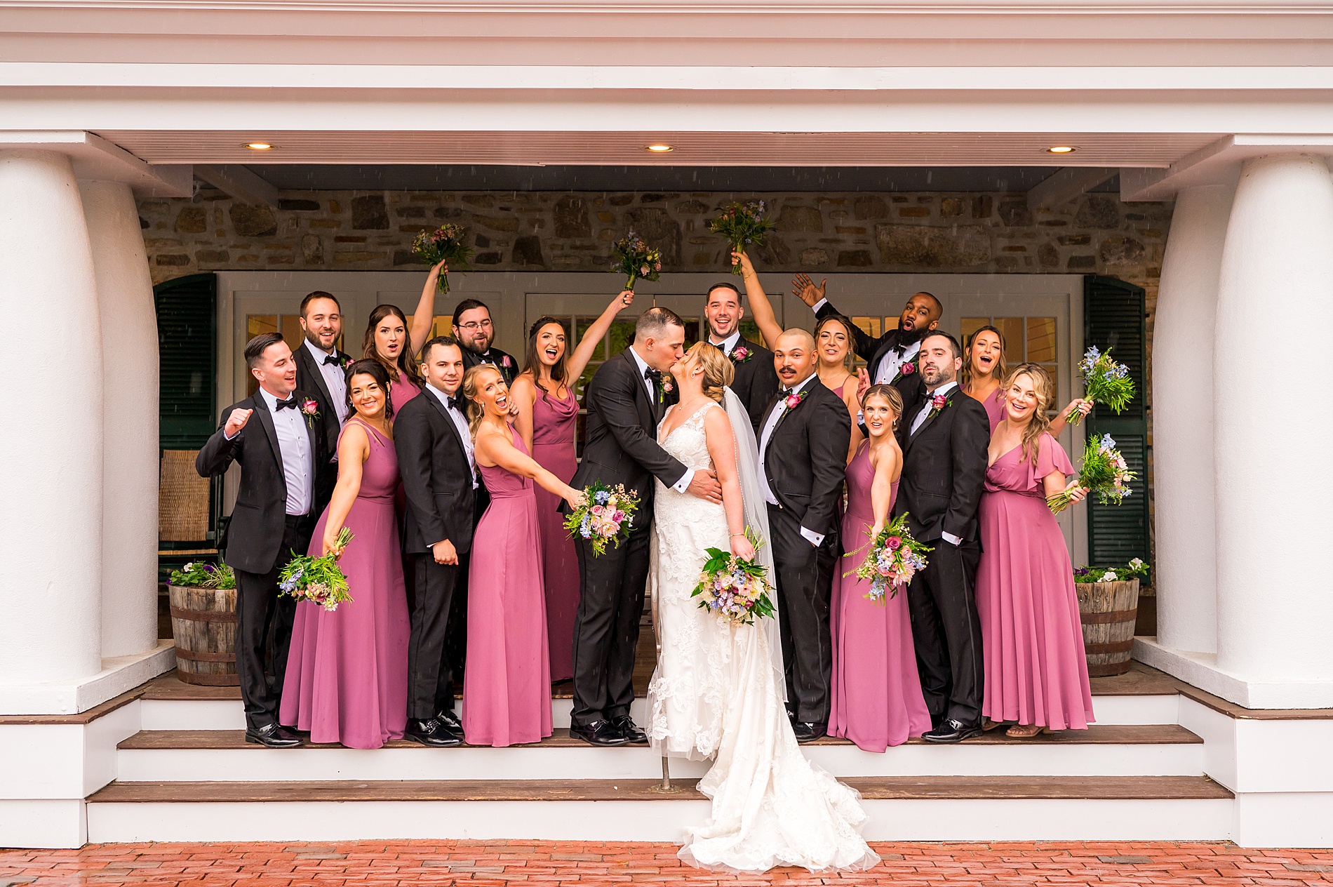 bride and groom kiss surrounded by wedding party from Spring Wedding at Church Landing