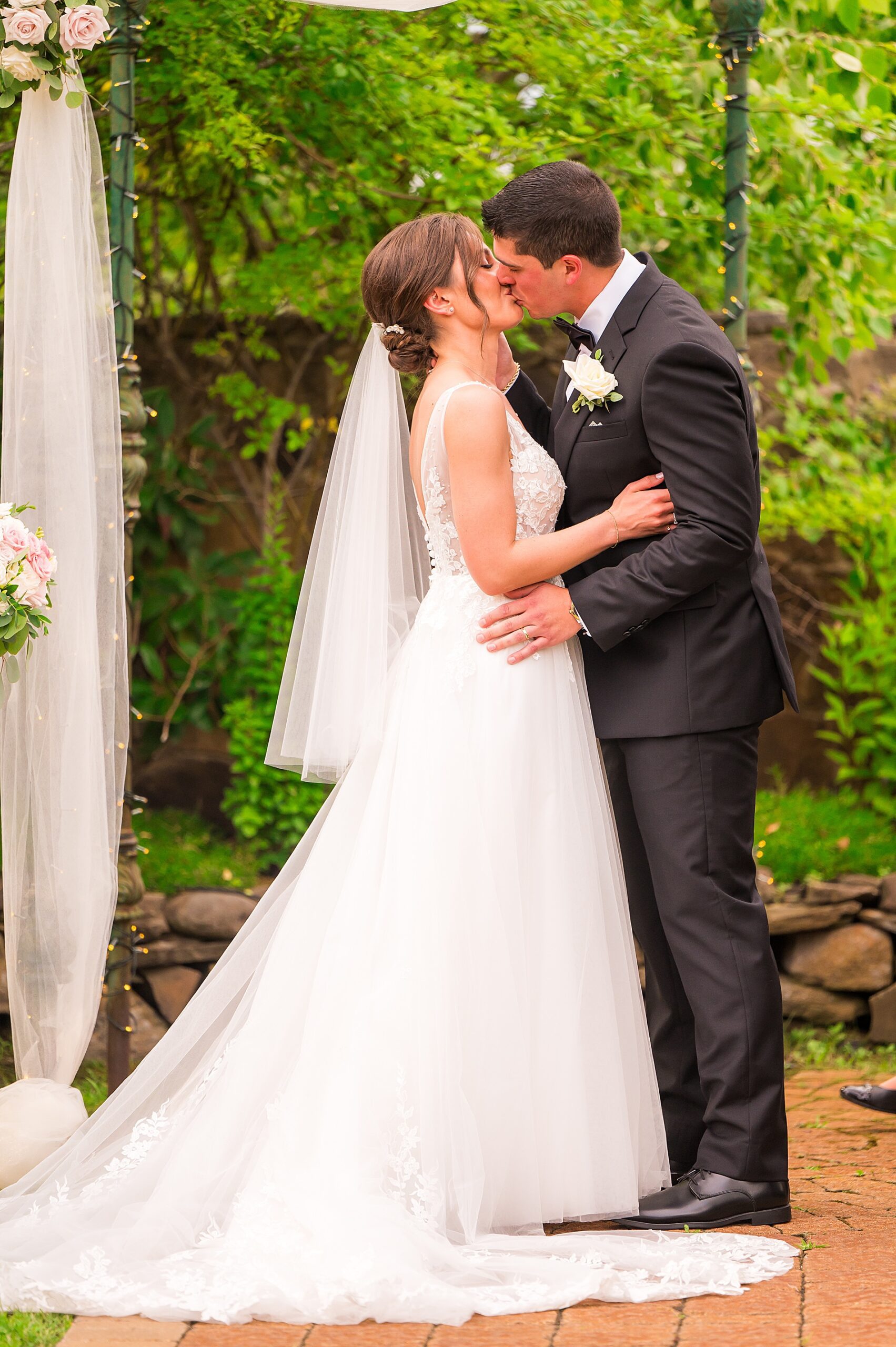 bride and groom kiss at wedding ceremony 