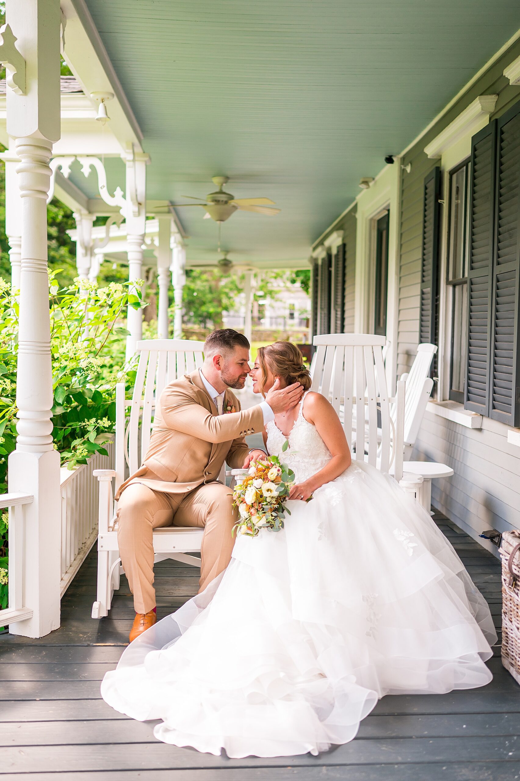 bride and groom sit on porch of Thompson Inn