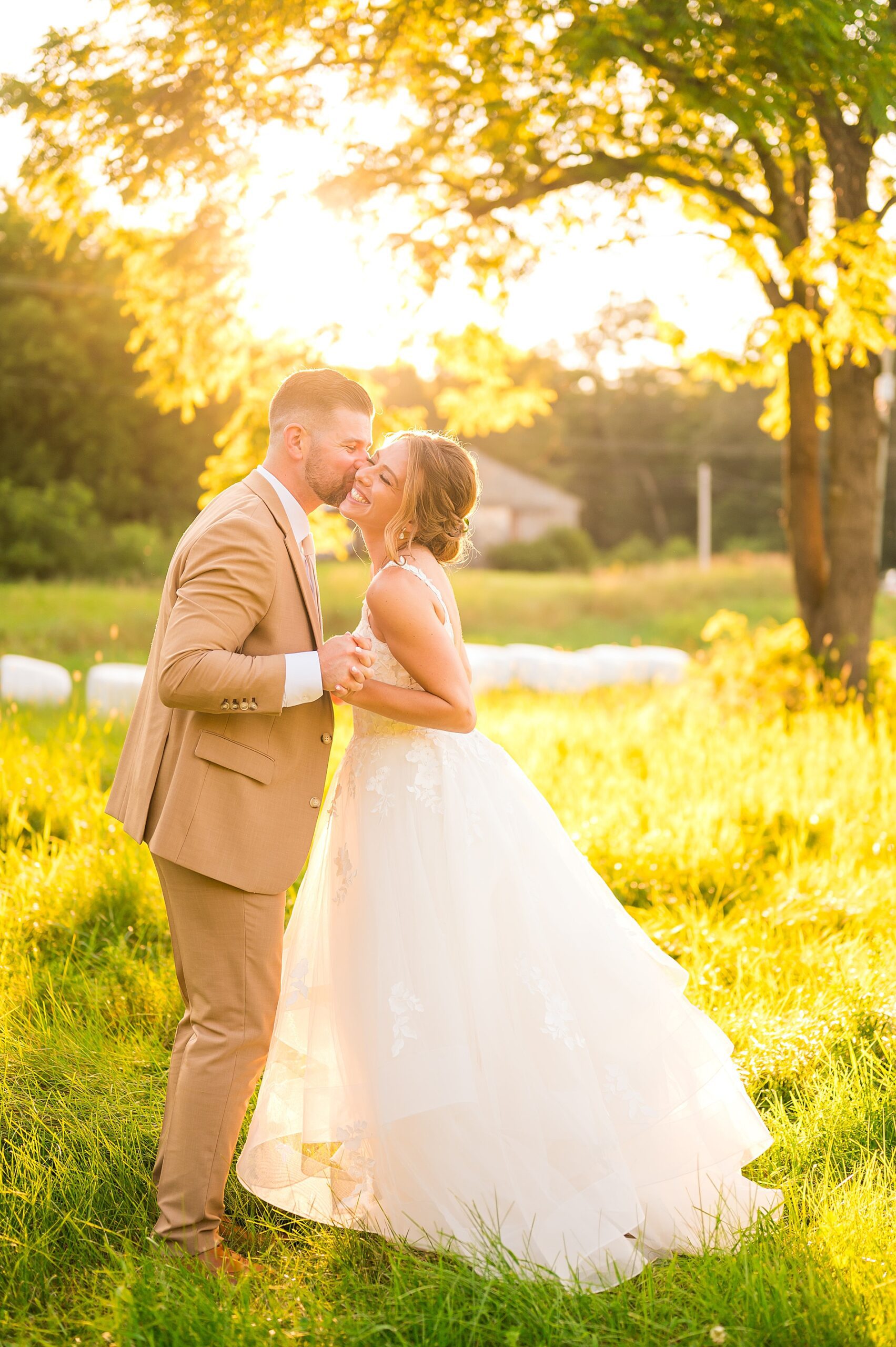 newlyweds kiss in the glow of the summer sun