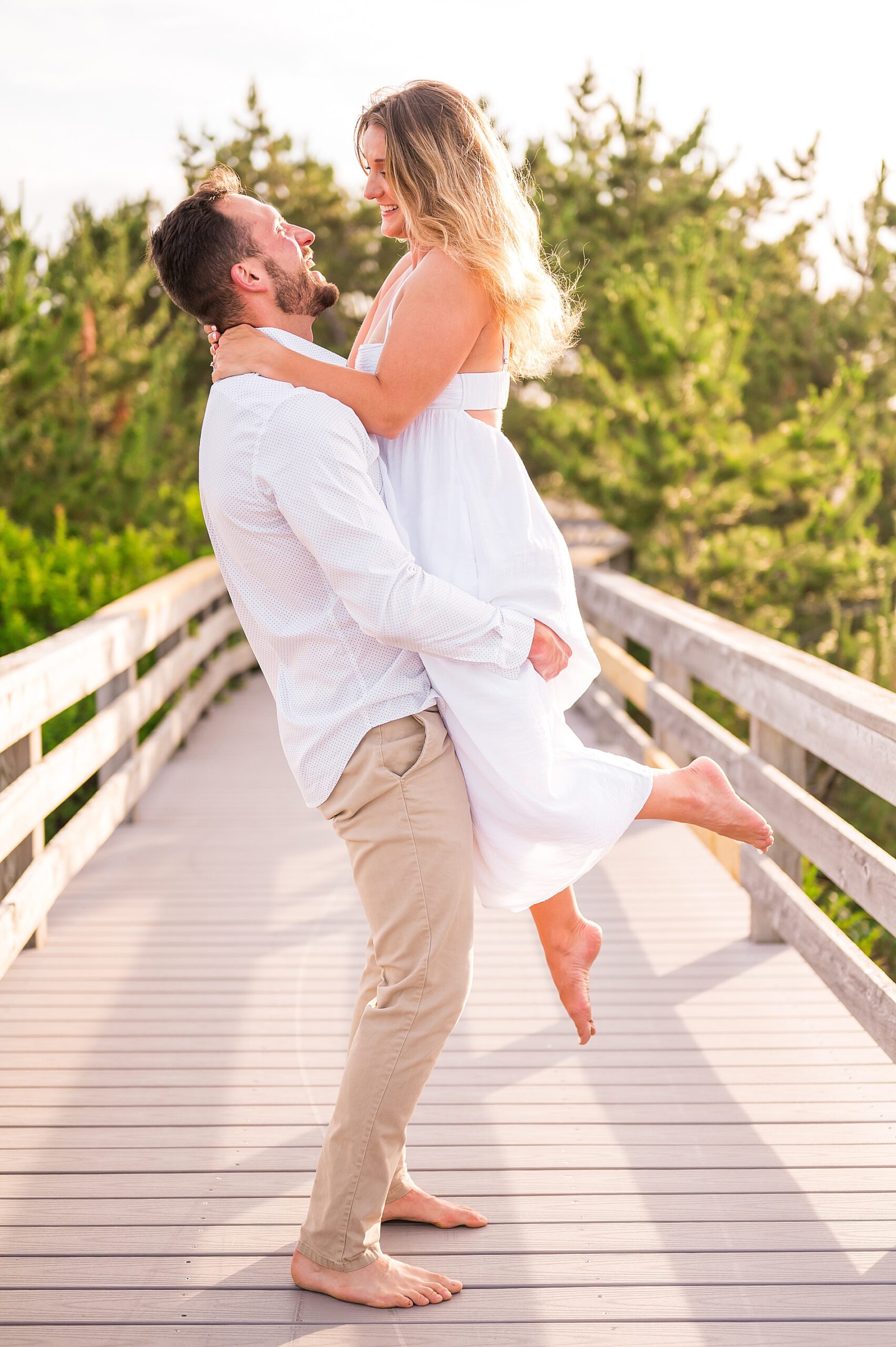 guy lifts up his fiance during engagement portraits