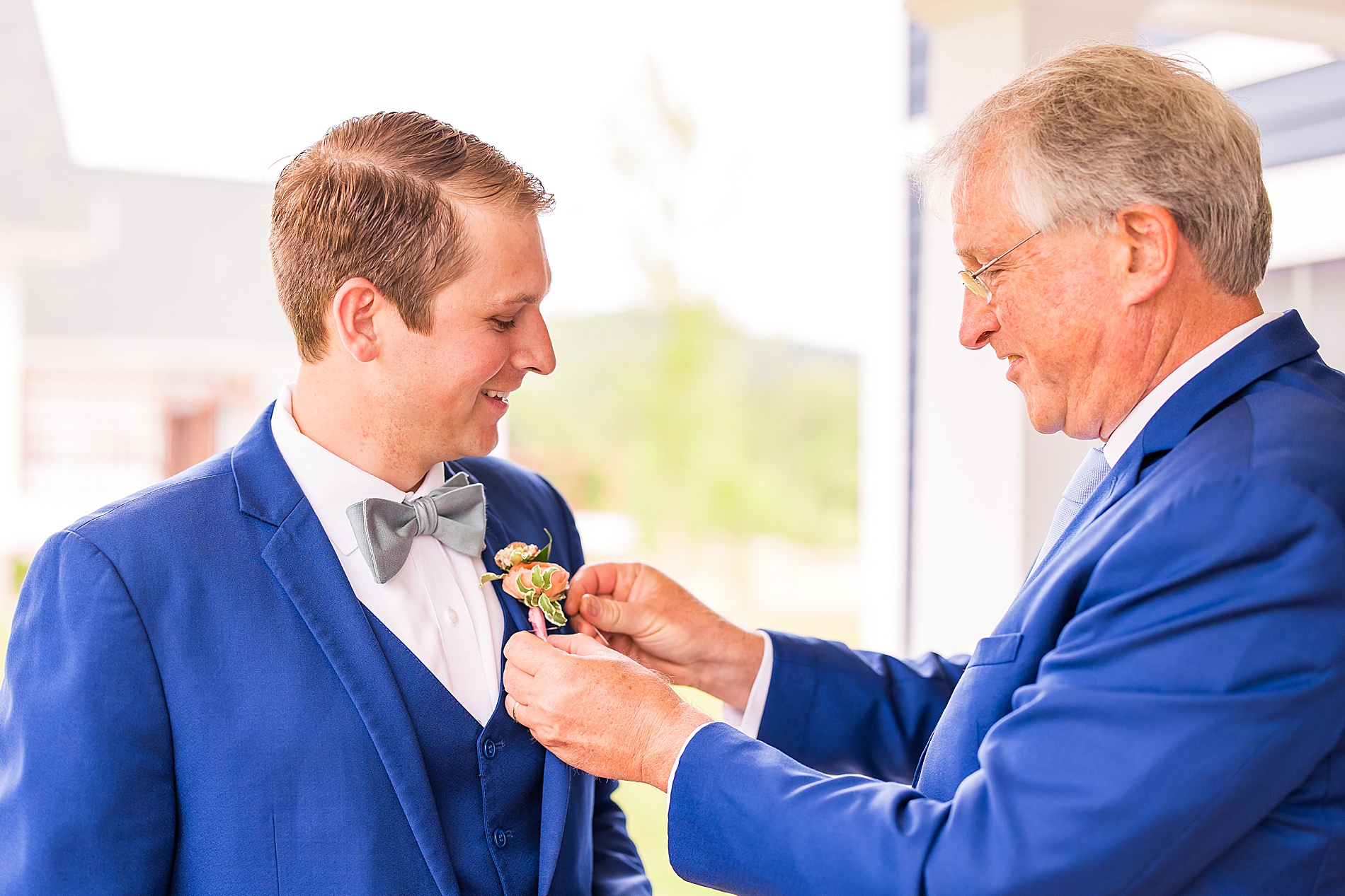 groom getting boutonniere on 