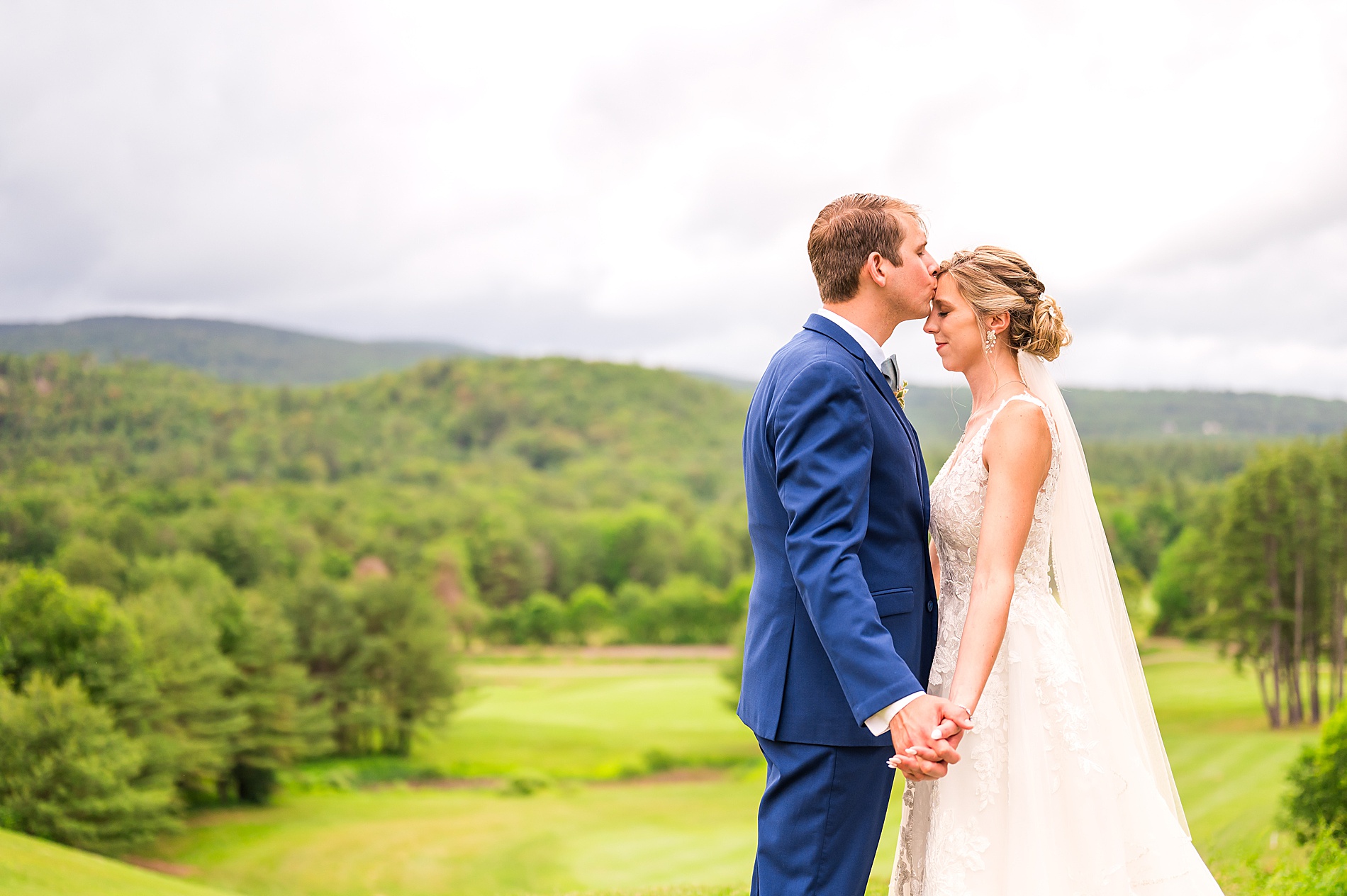 groom kisses bride's forehead during portaits