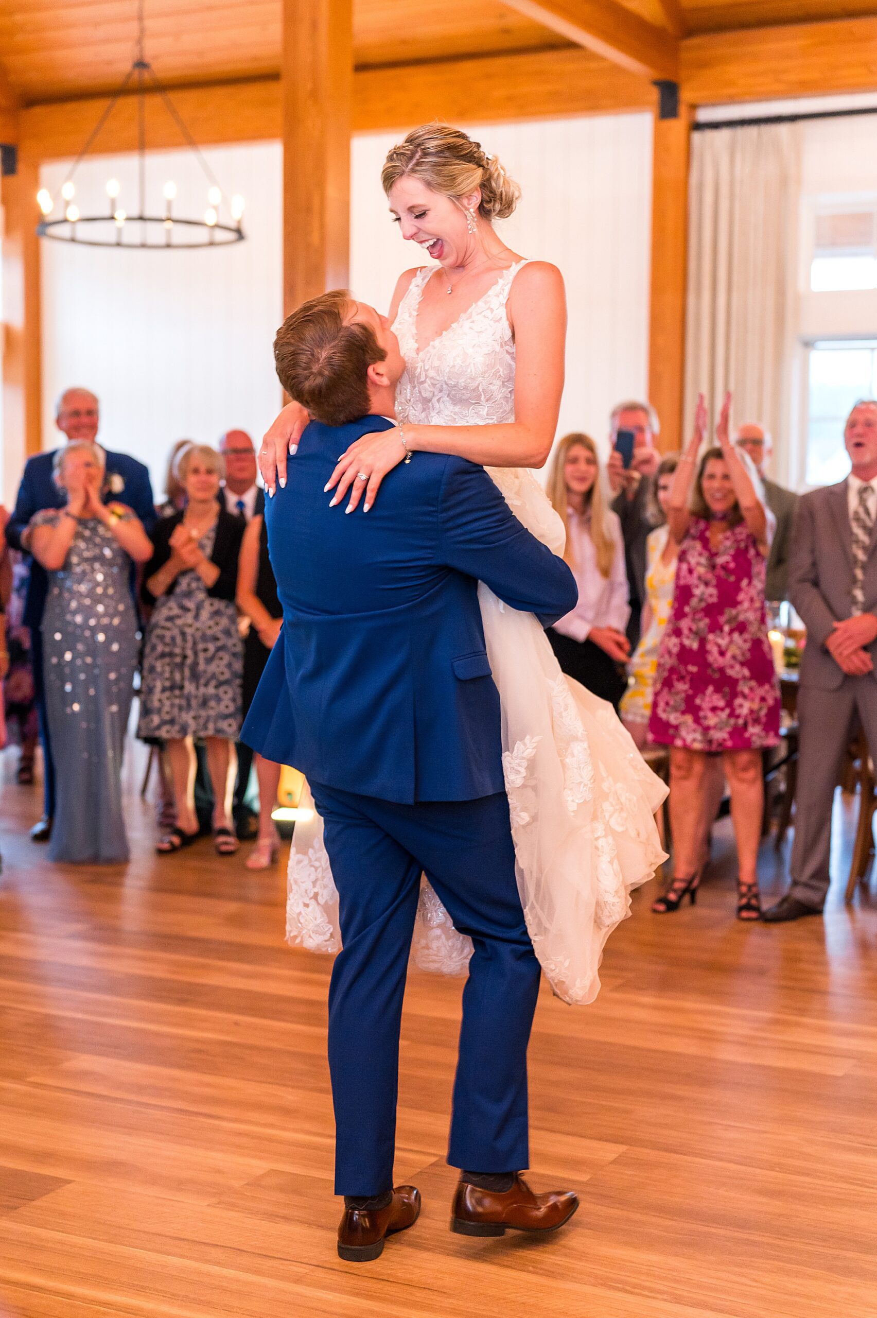 groom lifts bride up on the dance floor