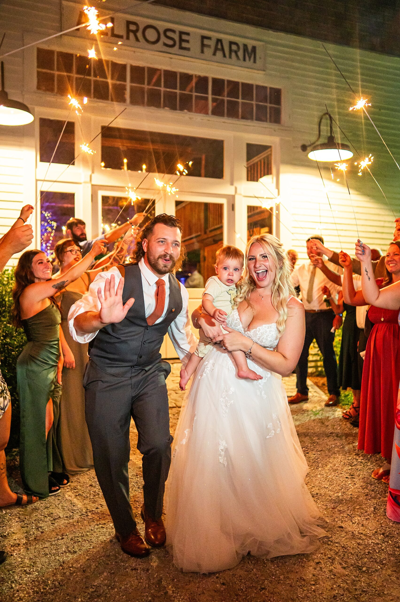bride and groom have sparkler wedding exit with their son 