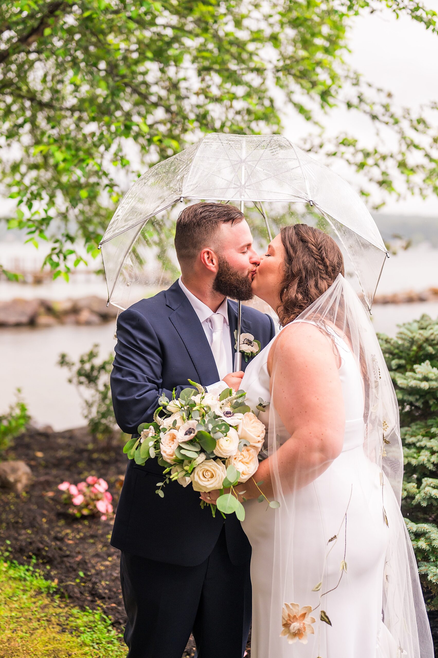 couple kiss during wedding portraits at The Margate, a lakefront wedding venue in NH