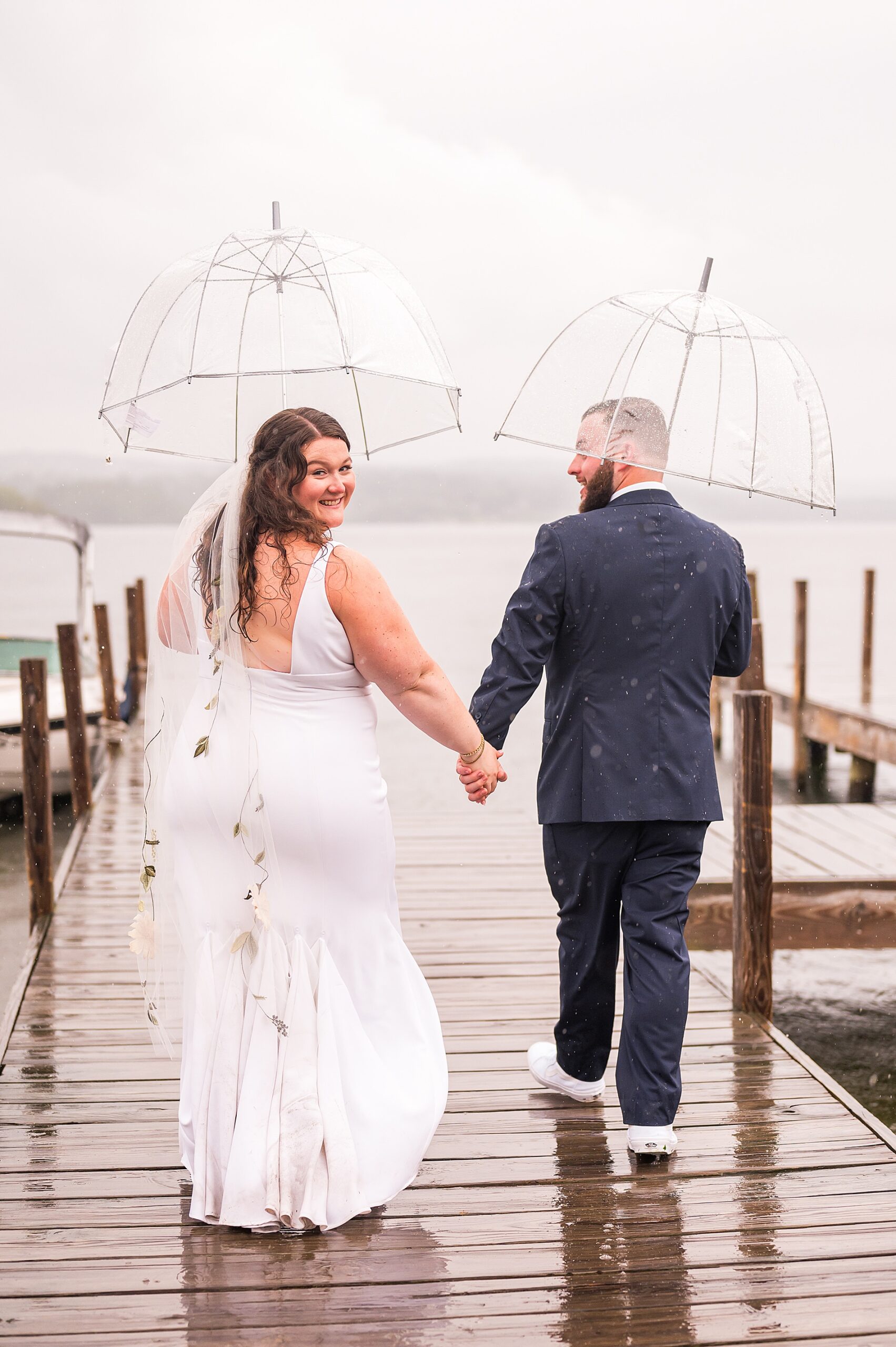 newlyweds hold hands as they walk the docks
