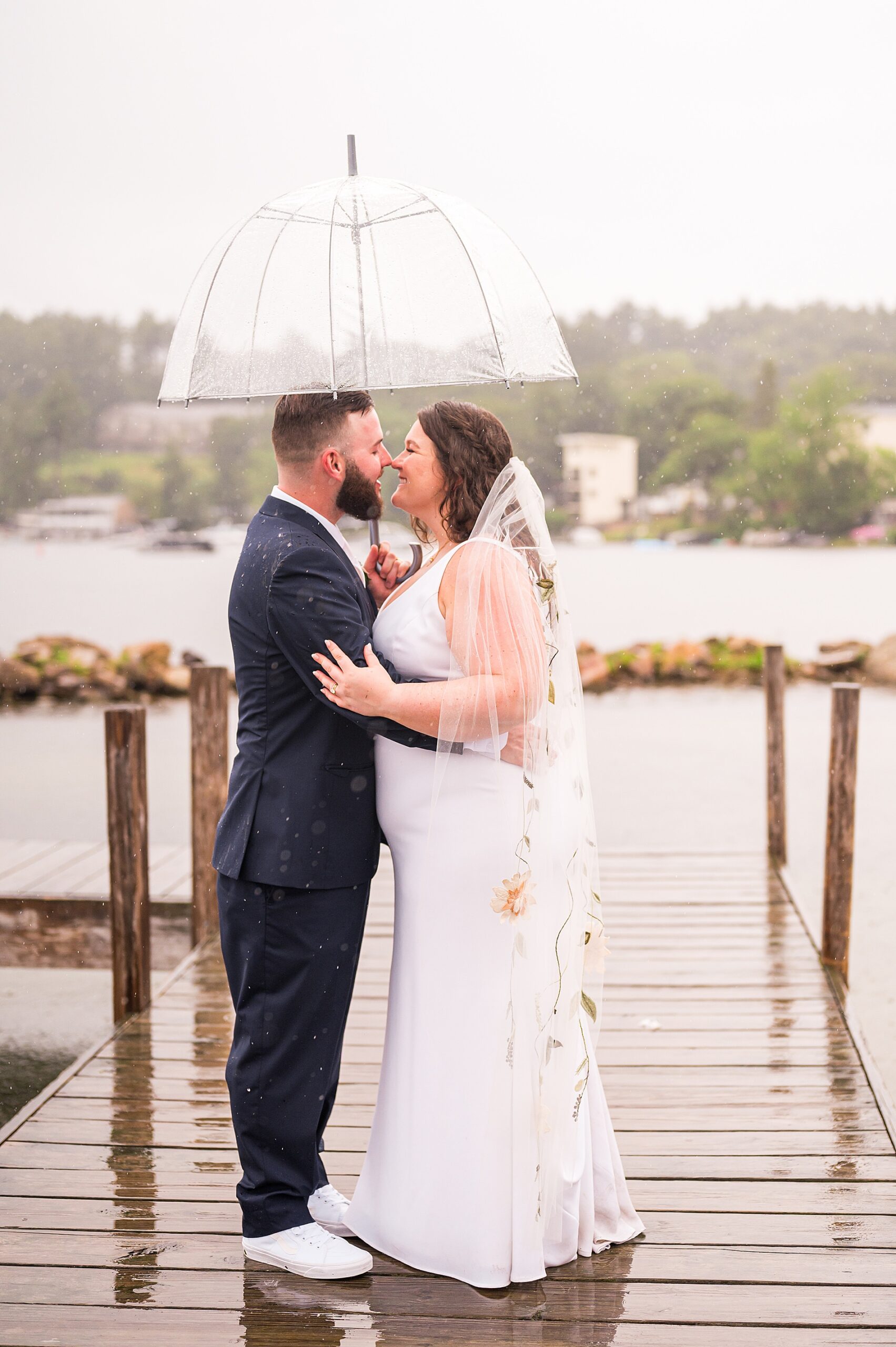 newlyweds under a clear umbrella 