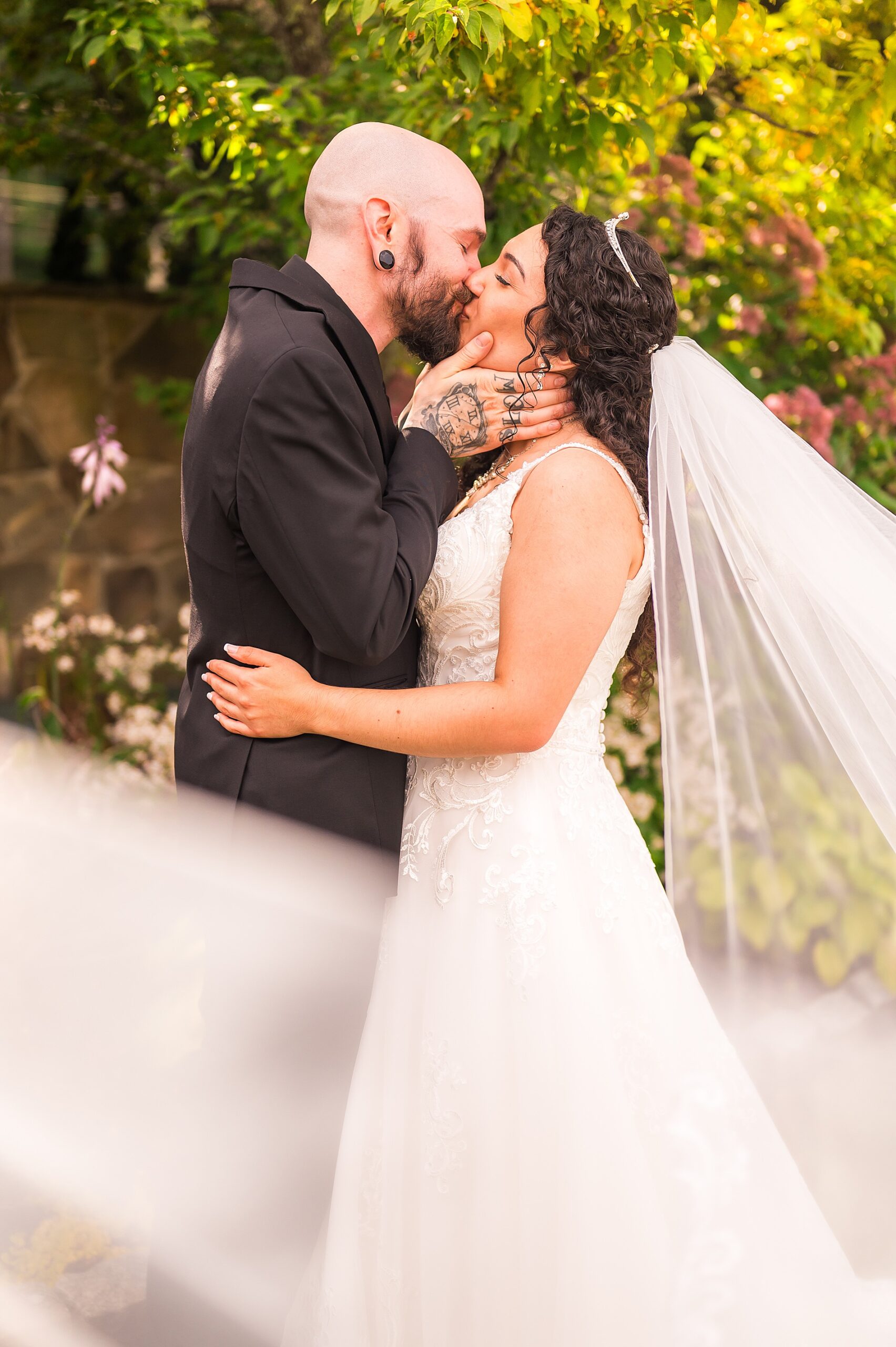 newlyweds kiss as bride's veil flows around them