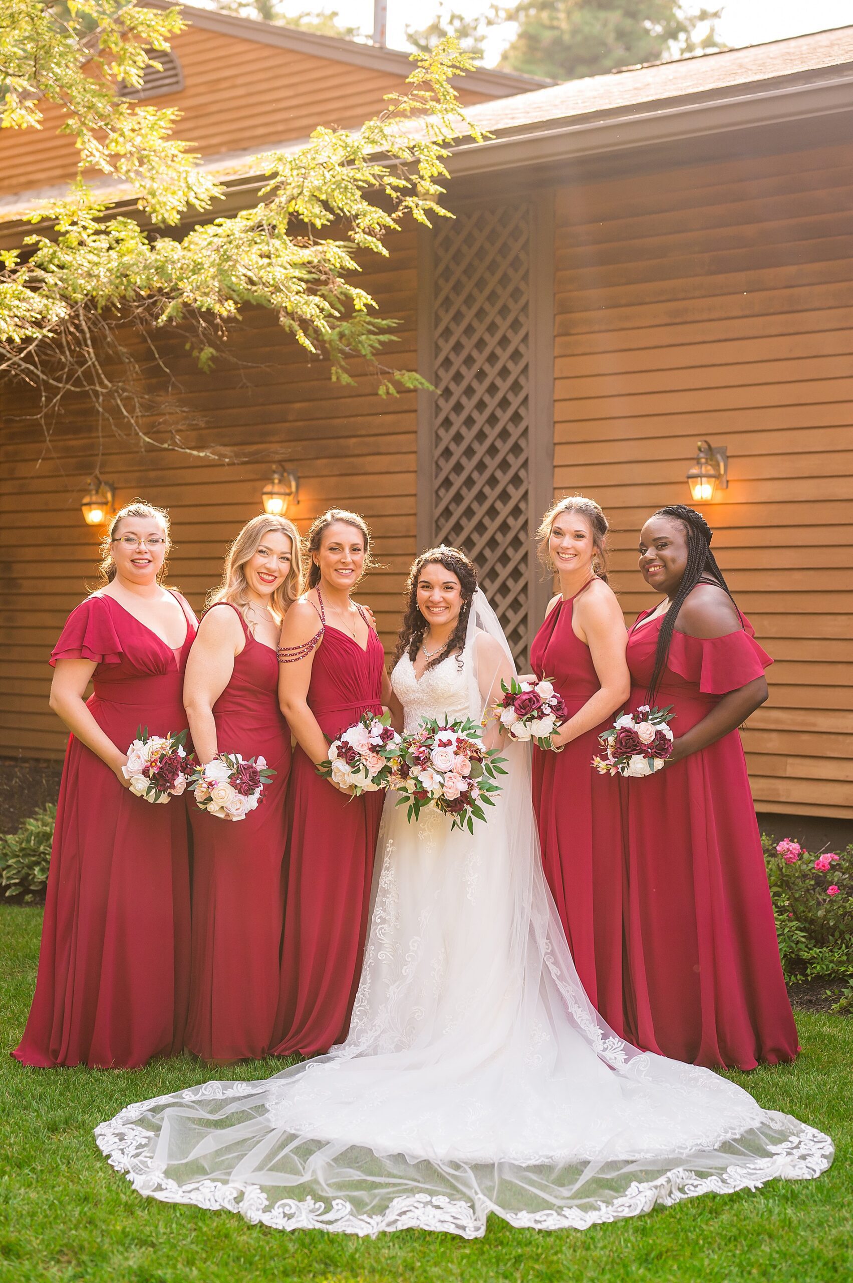 bride with bridesmaids in burghandy dresses 