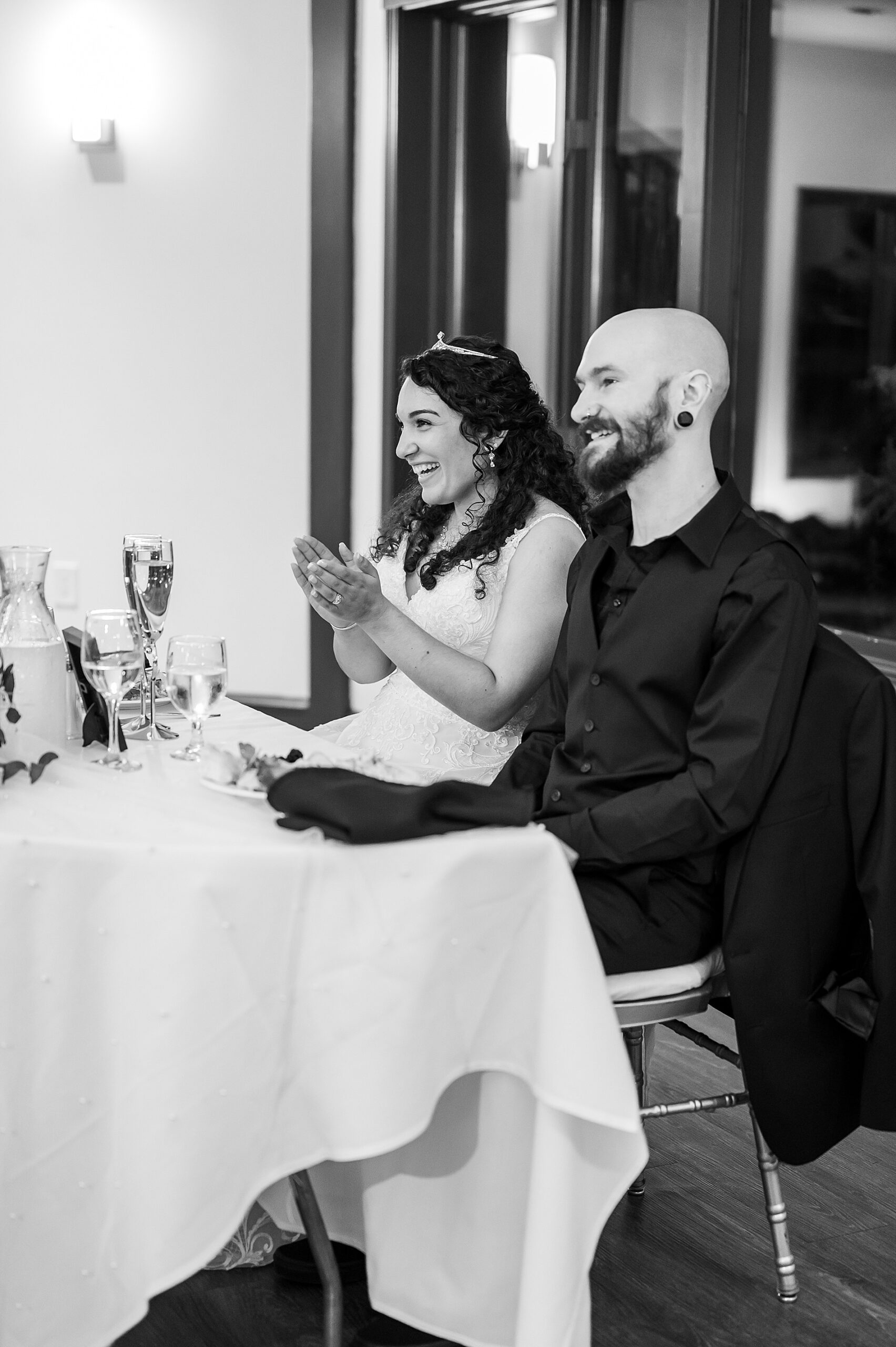 bride and groom laugh during wedding toasts 