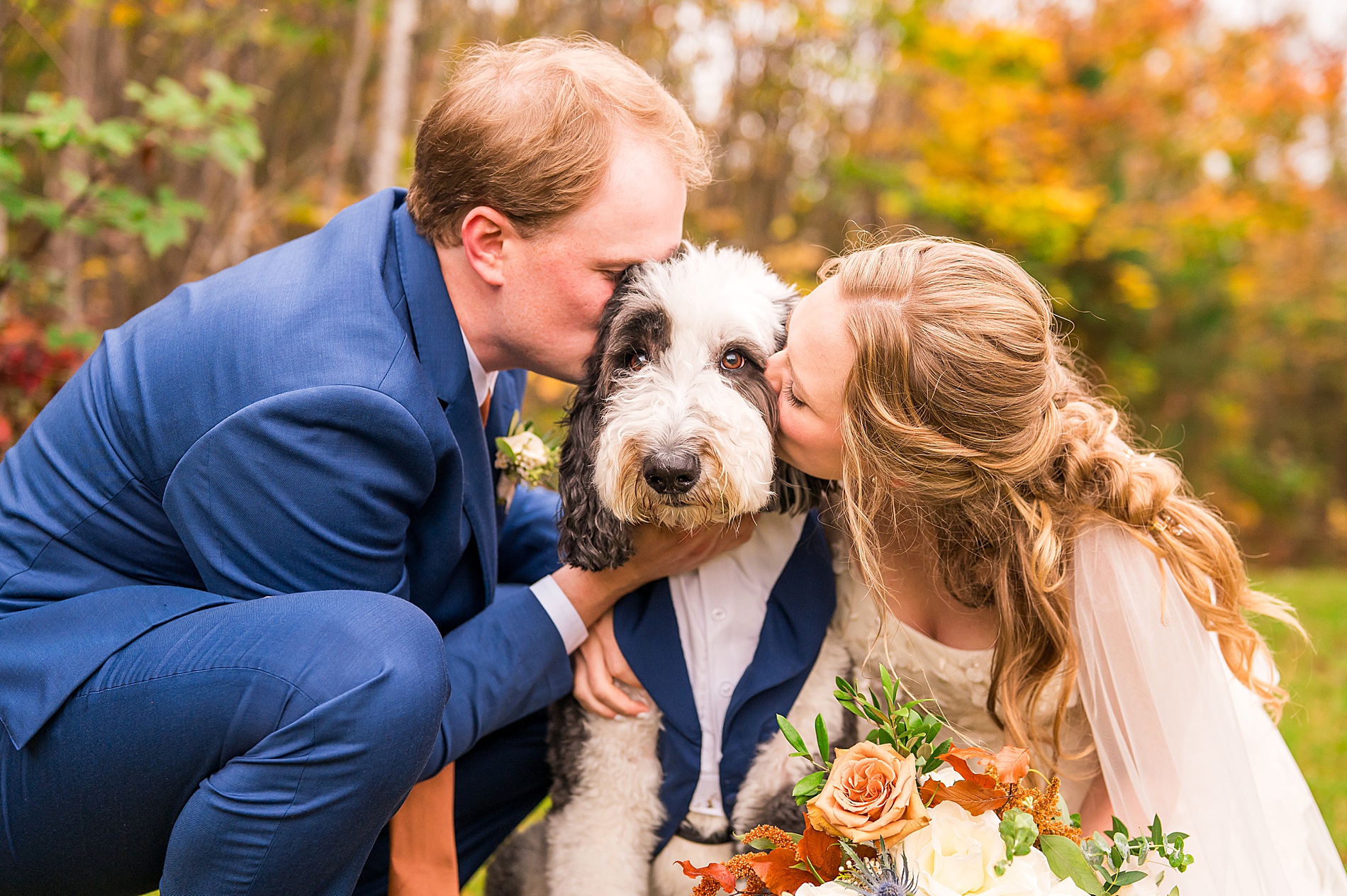 bride and groom kiss their dog 