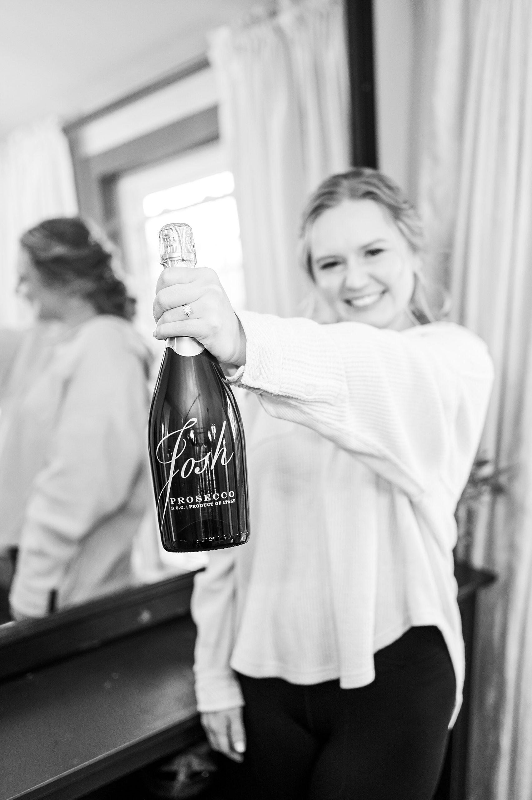bride holds champagne bottle