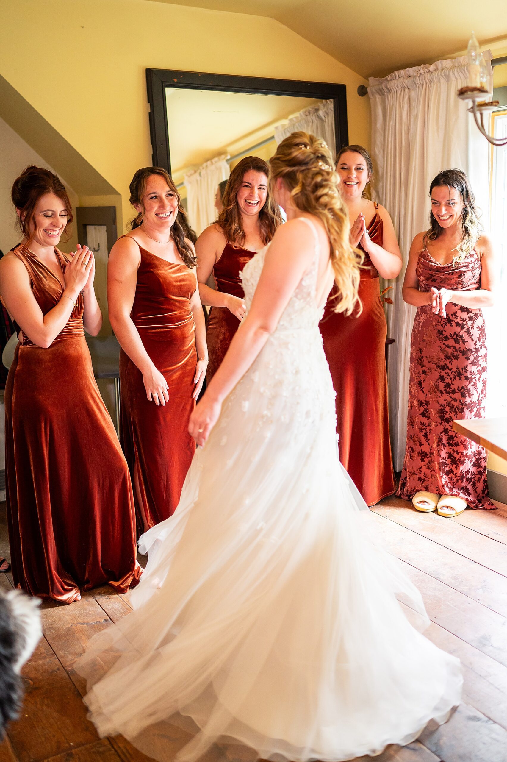 bride twirls in wedding dress in front of bridesmaids
