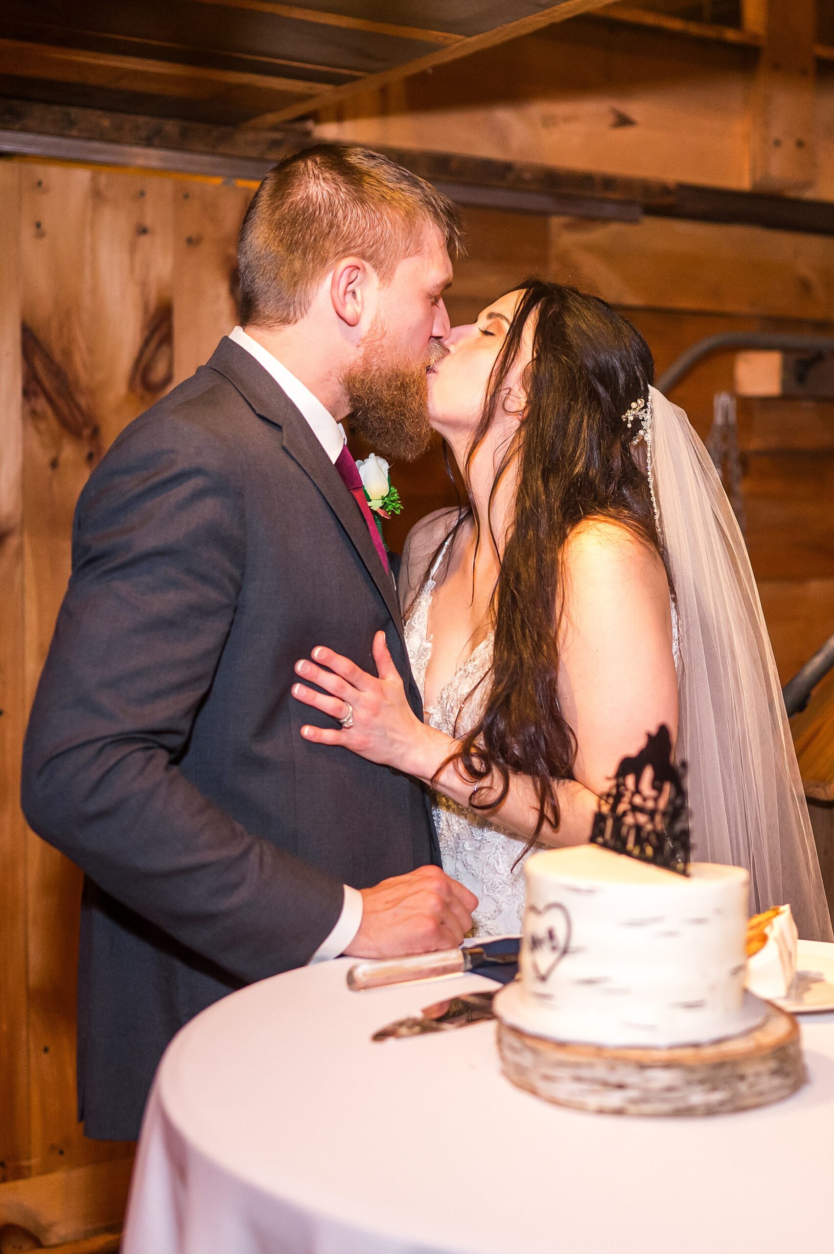 newlyweds kiss cutting wedding cake