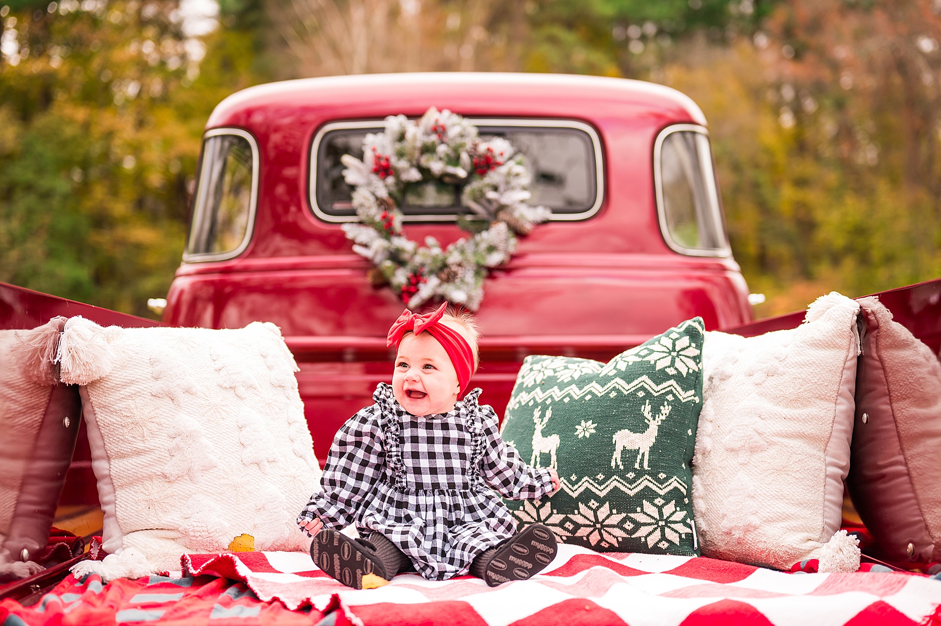 baby sits in decorated red truck 
