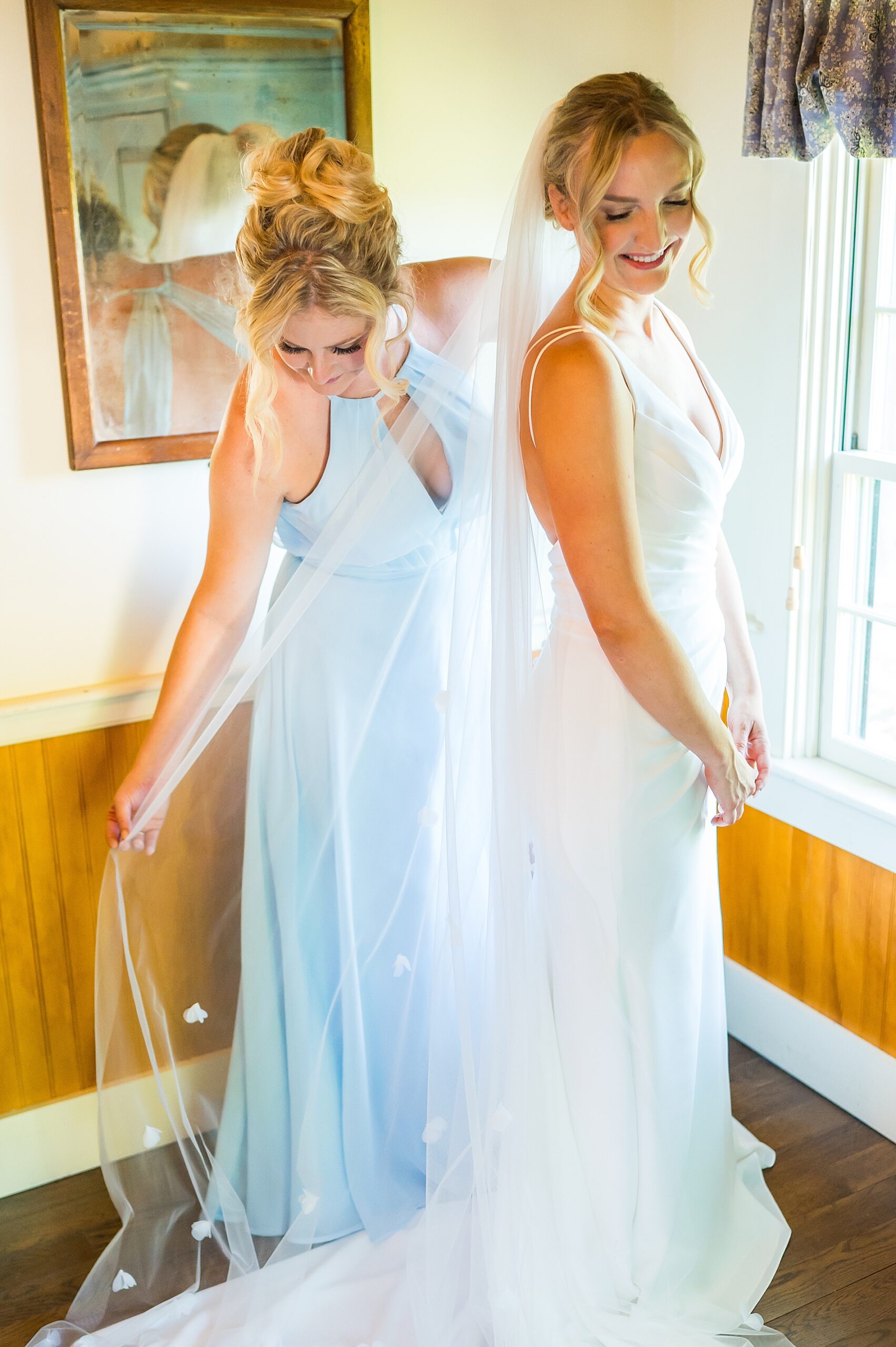 bridesmaid helps bride with veil