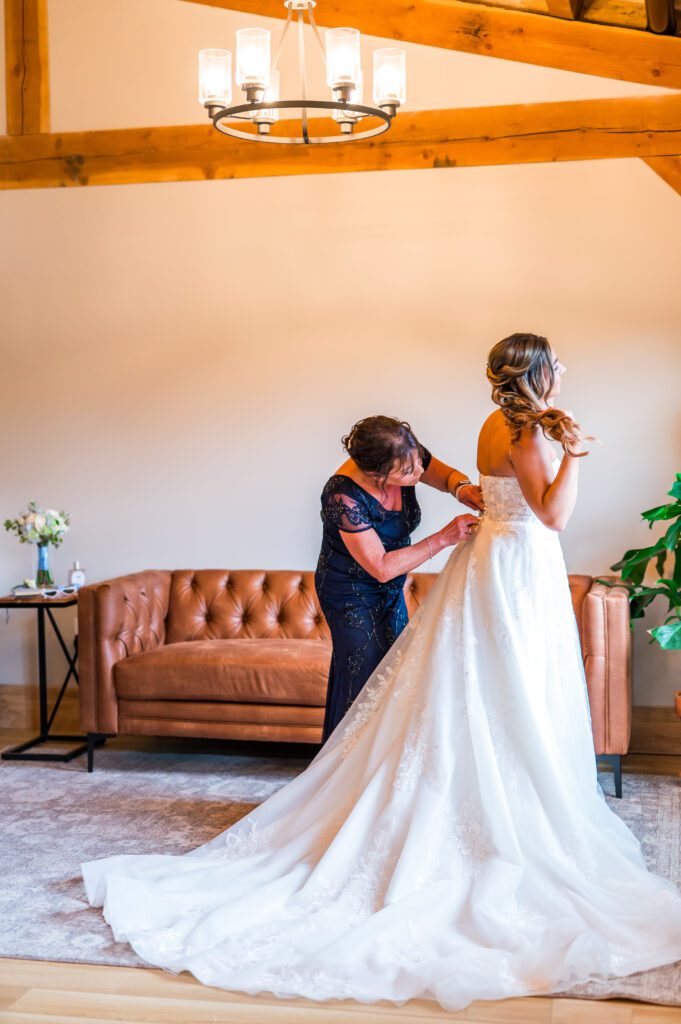 Mom zipping up bride dress