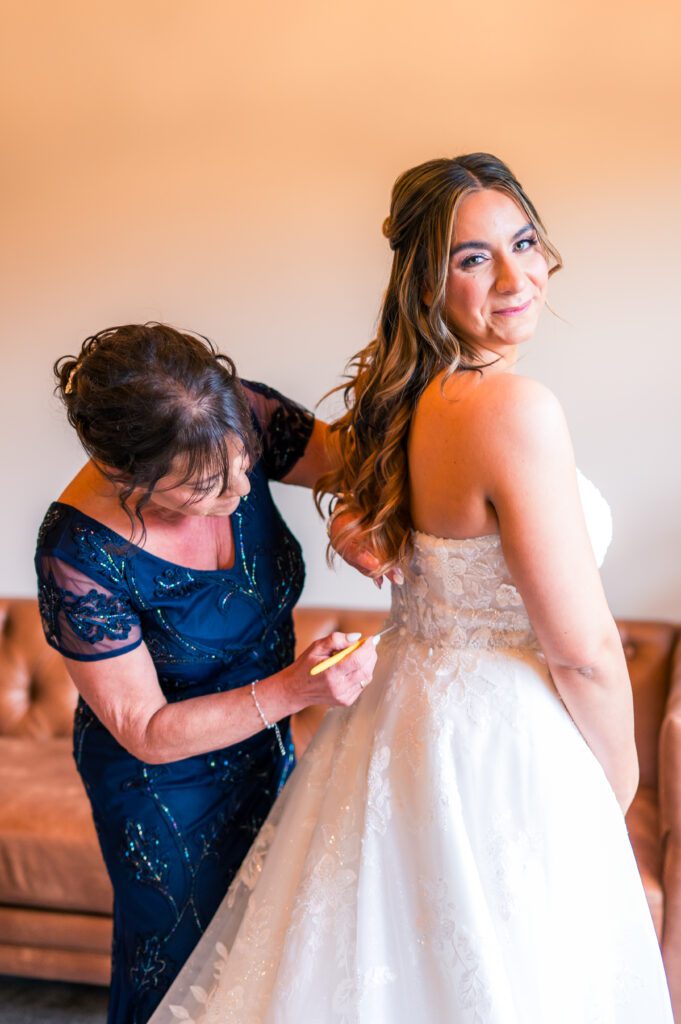 Mom zipping up dress | Wedding