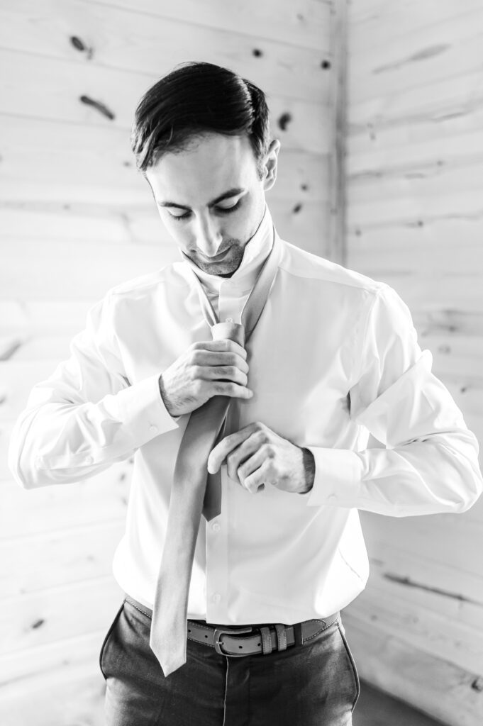 Groom putting on tie | NH Wedding